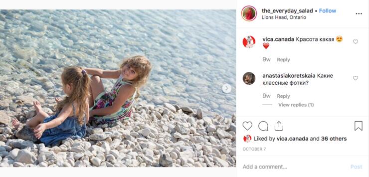 Two young girls playing on a cobblestone beach.