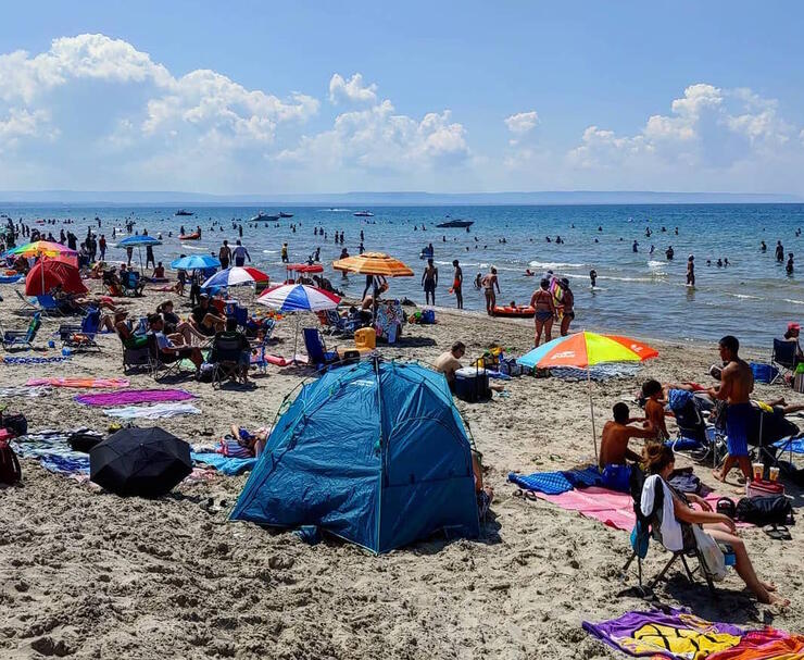 Colourful sun shelters shade beachgoers from the sun.