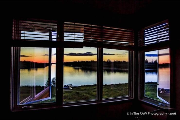 View through window of sunset over a river.
