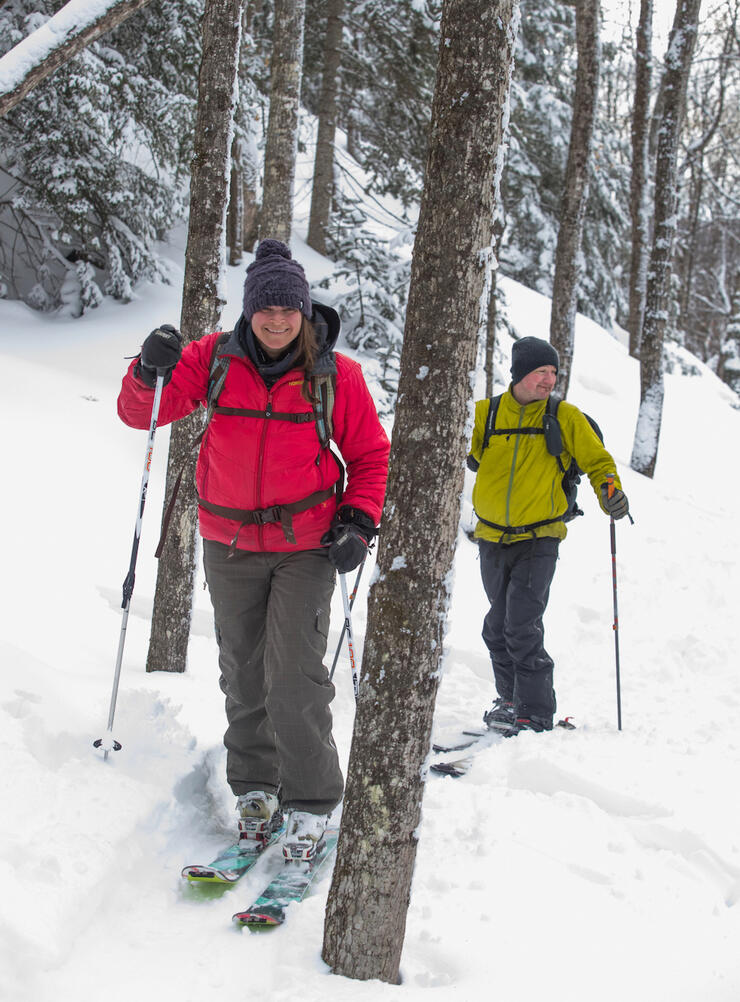 two people backcountry skiing in powder