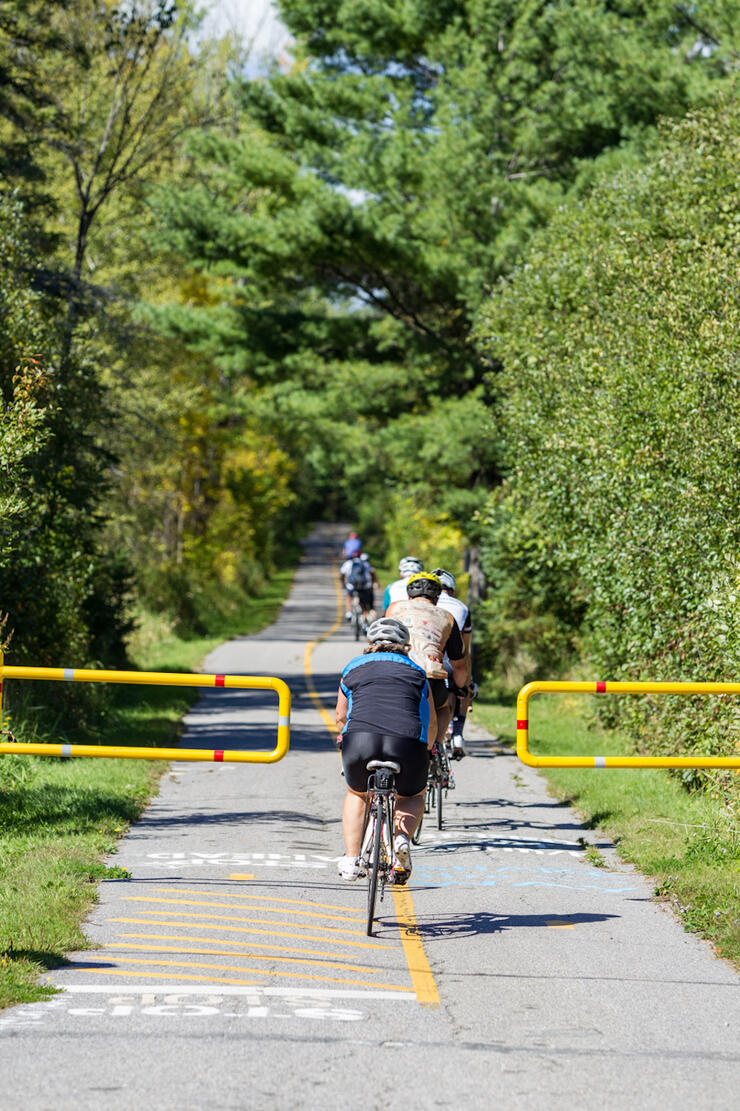 Cyclists ride through the gates at the start of a bike trail