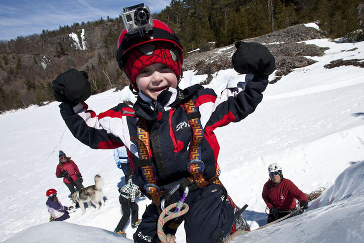 Little boy smiling after climbing up a small slope.