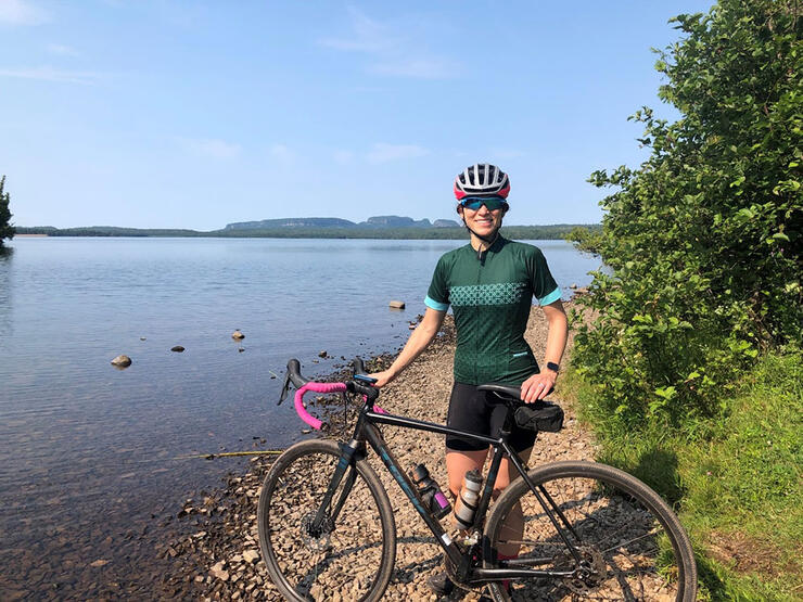 Woman cyclist poses in back of Thunder Bayâs iconic Sleeping Giant landform