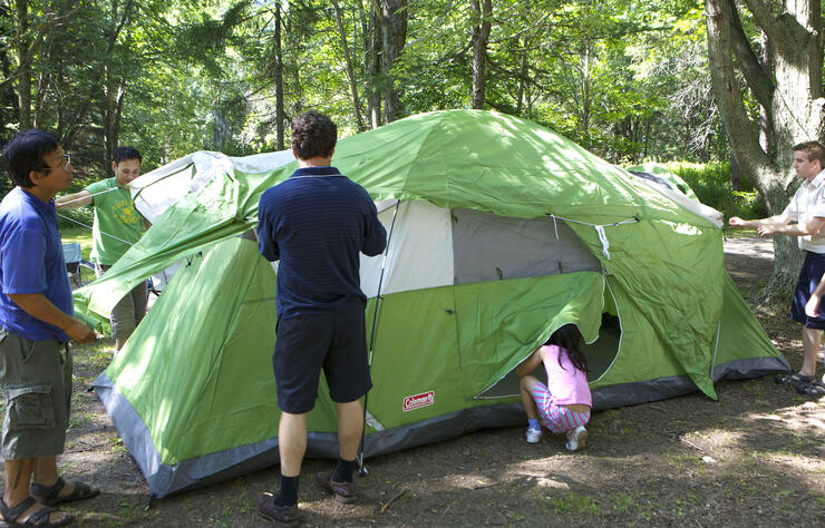 Group of people setting up a tent with Ontario Parks staff. 