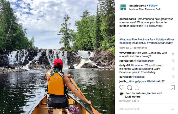 Instagram post of woman paddling a canoe approaching a waterfall