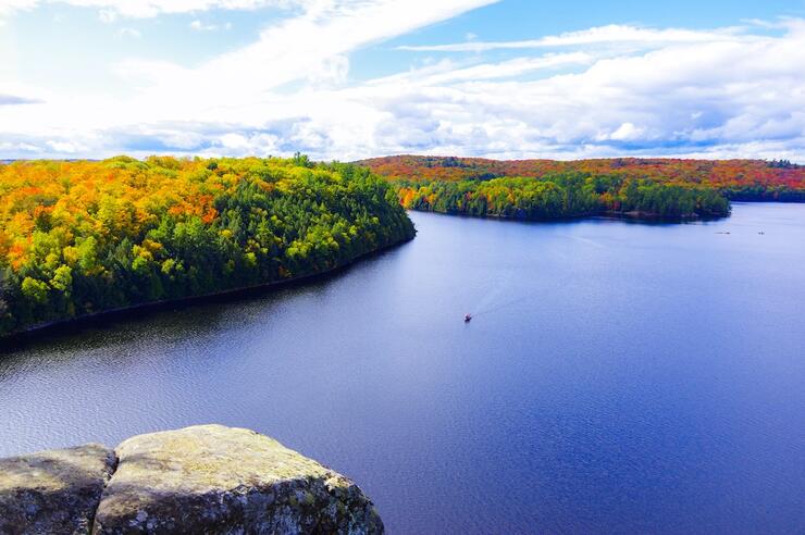 View over lake with colourful trees lining the shore.