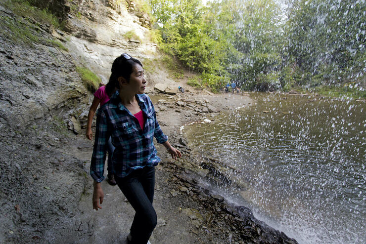 People walking behind waterfall