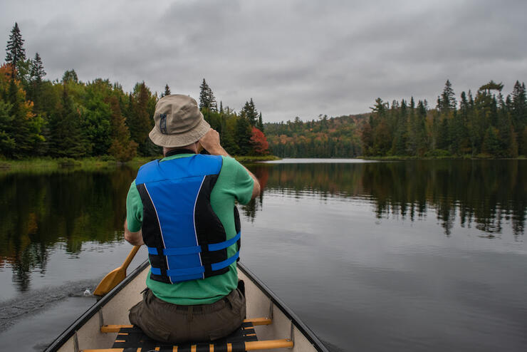 Man wearing a bucket hat in a canoe
