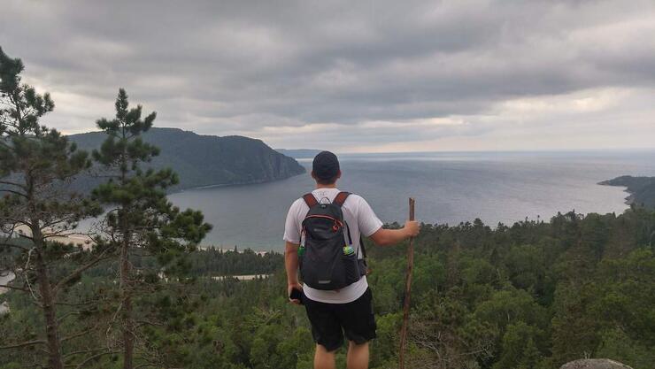 Man on a hiking trail looking over a cliff