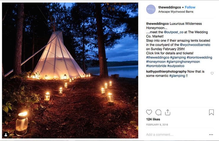 Lakeside teepee at night with candles lighting a path