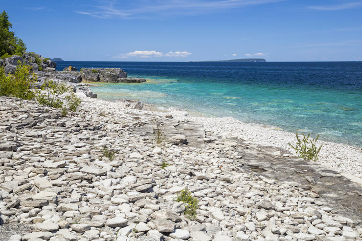 Turquoise water by a rocky shore of one of the blue-water lakes in ontario