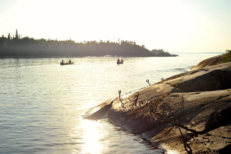 people paddling at sunset
