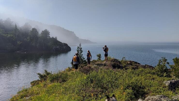 People standing on the edge of a foggy river