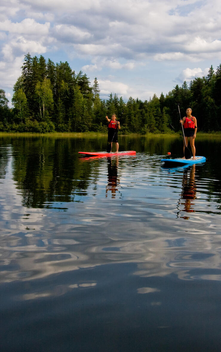 Two people on red paddleboards