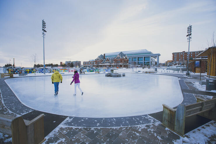 Two people skating on outdoor rink