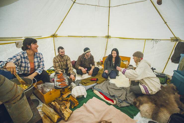 Group of happy people inside a heated canvas tent