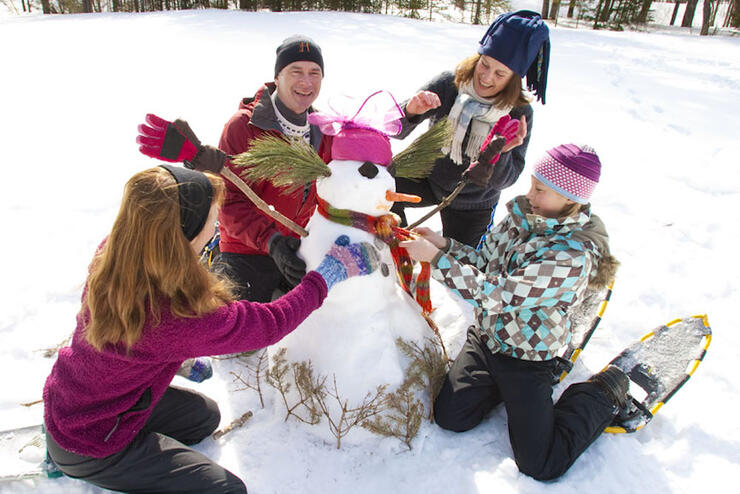 Group of people building a snowman. 