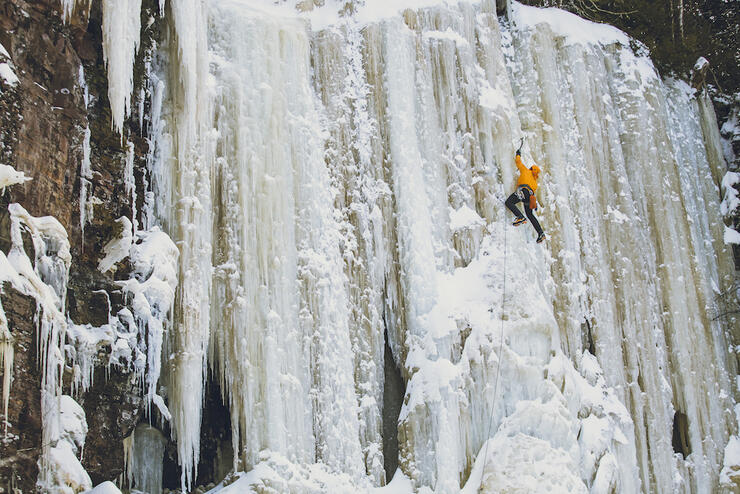 Man climbing up a frozen waterfall. 