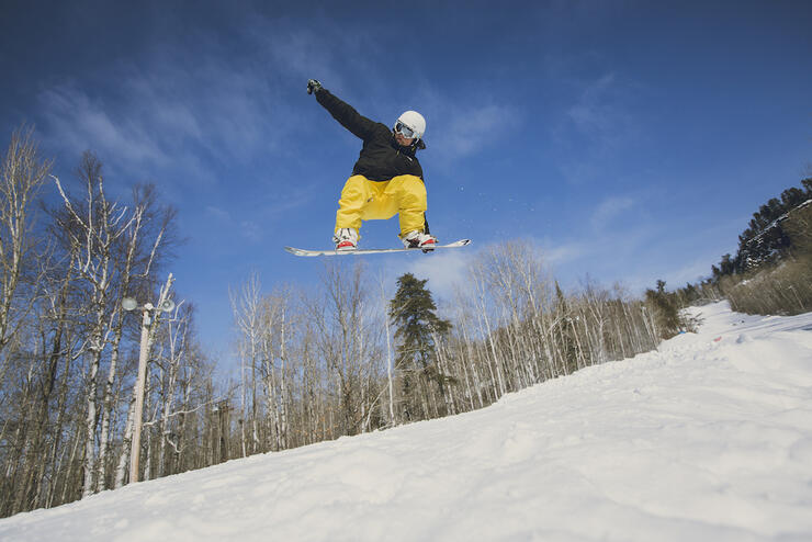 Young man catching air on a snowboard