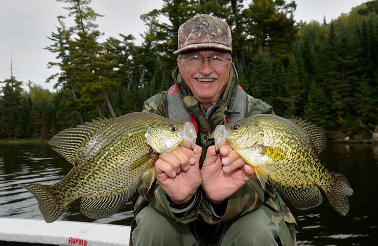 angler holding 2 black crappie