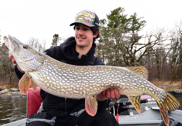 young angler holding northern pike