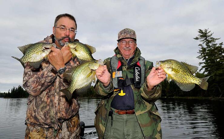 two anglers holding black crappie