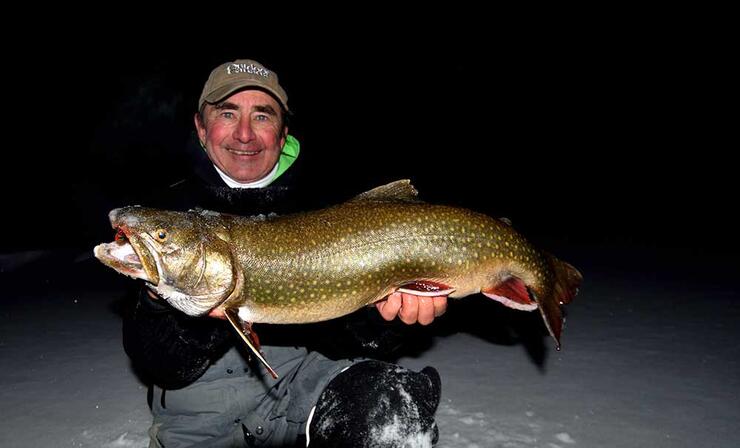 angler ice fishing lake trout