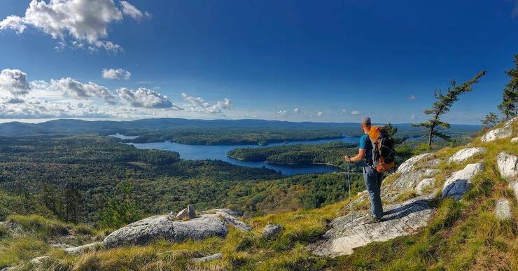 Man on rocks overlooking lake in distance