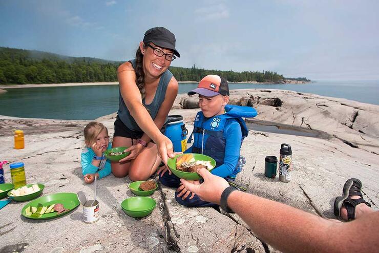 family sitting on rock eating