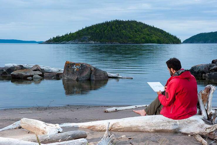 person sketching lake superior shoreline