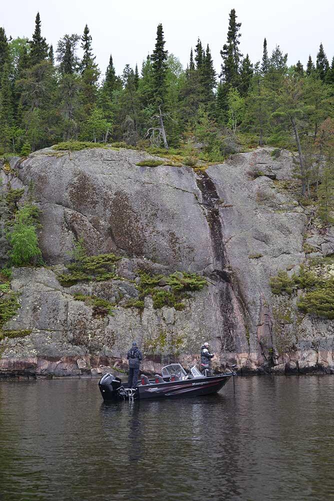 fishing boat on a lake with rock cut